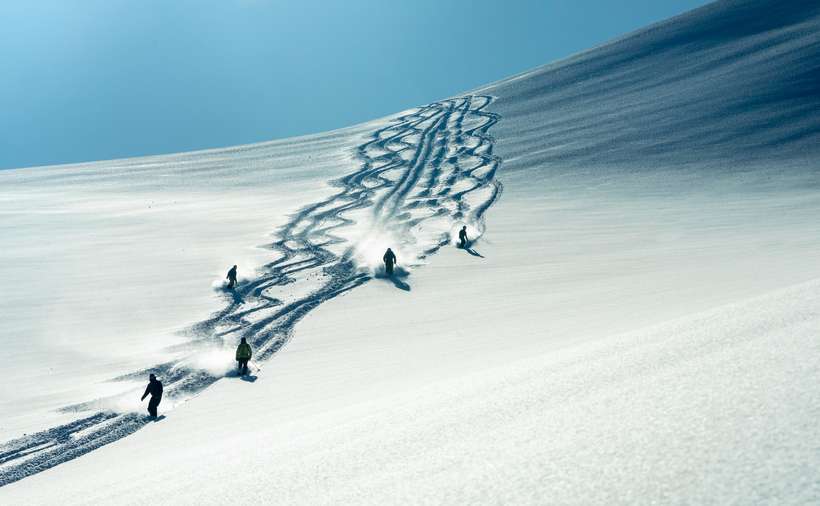 Arctic Circle - A group of heli-skiiers exploring the slopes in Northern Norway